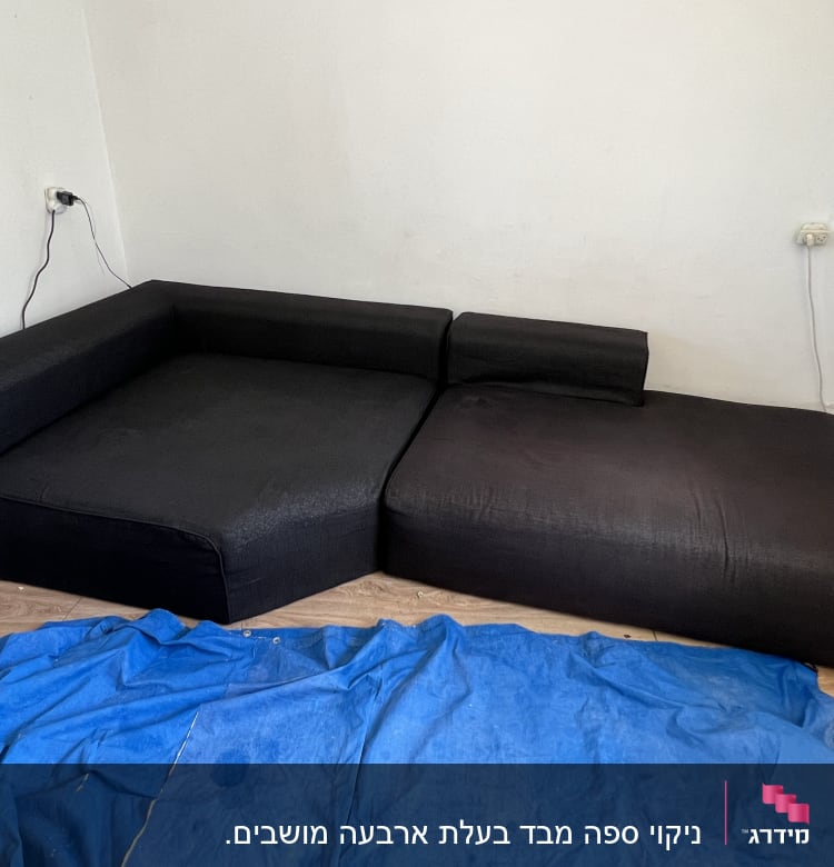 ספה שחורה עם כיסוי כחול על הרצפה